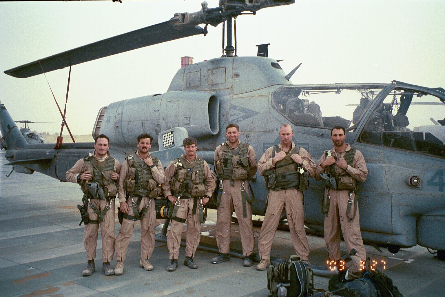 Taken shortly after we finally made it back to Kuwait after the long sandstorm, 27 March 2003. From left to right: Weasel, Shoe, Gash, BT, Fuse, IKE. Missing are Spock and JoJo–still in Iraq after being shot down during the final mission of those four days. It would be several more days before maintenance Marines could repair all the damage and make their aircraft flyable again. pg 210